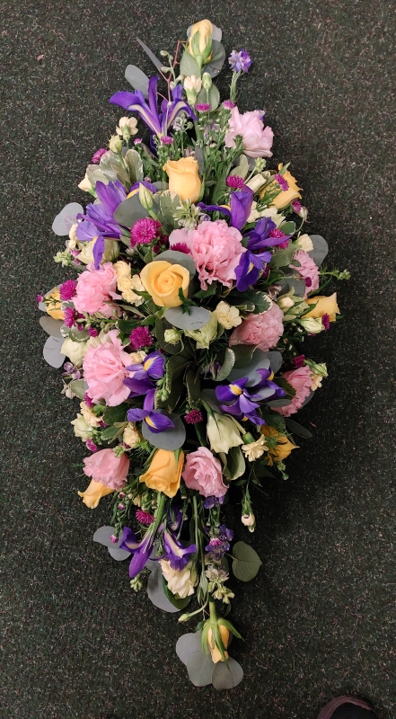 Yellow, pink, and purple casket spray